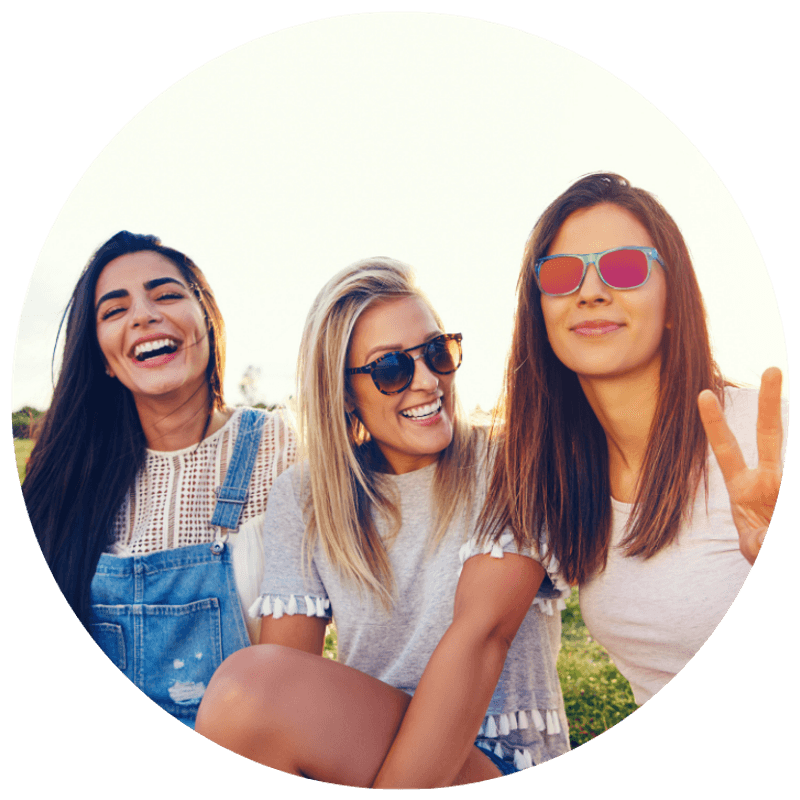 Three young women laughing together outdoors